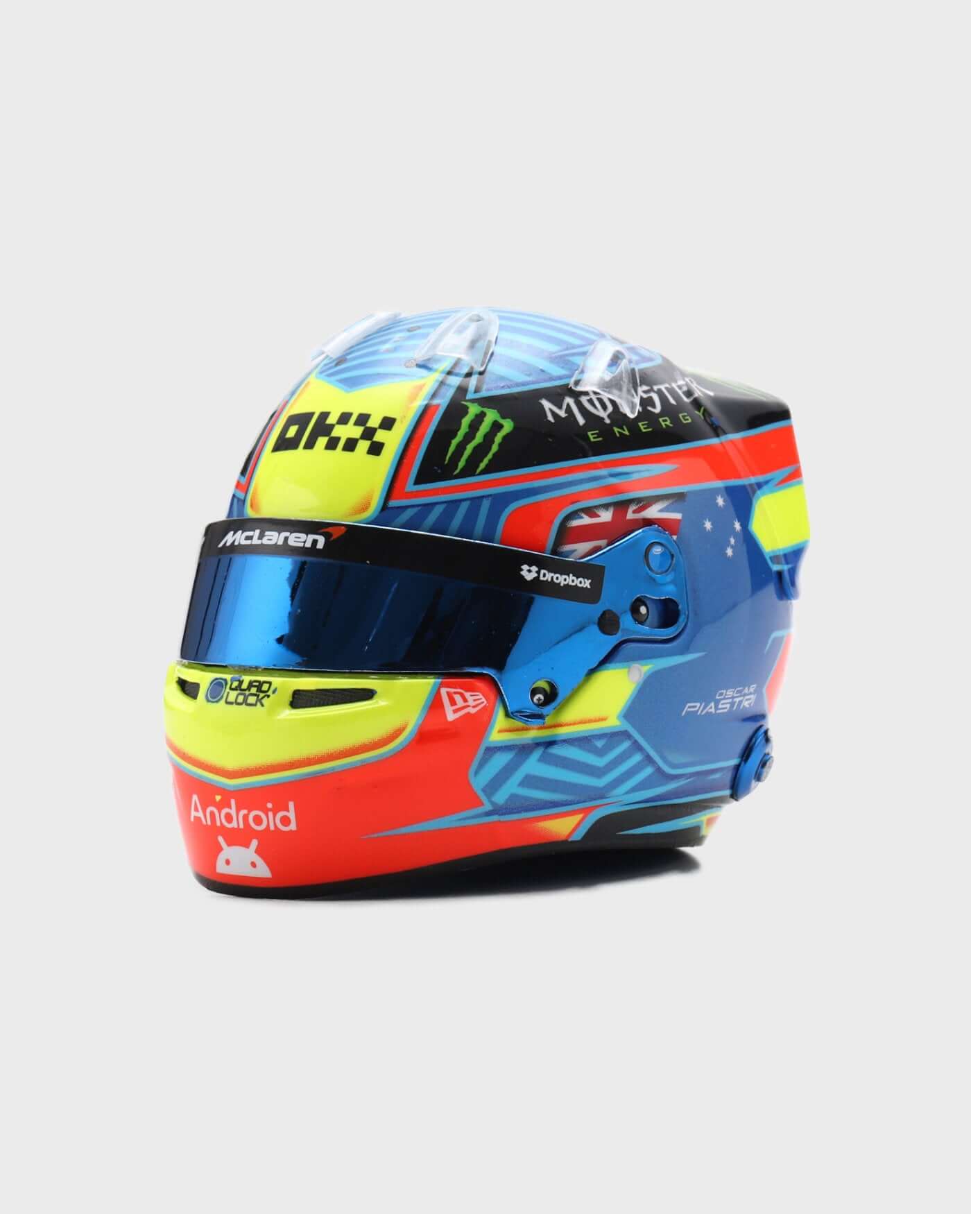 1:5 scale 2024 Oscar Piastri racing helmet replica by Spark, featuring red, blue, yellow design and personal logo for F1 fans.