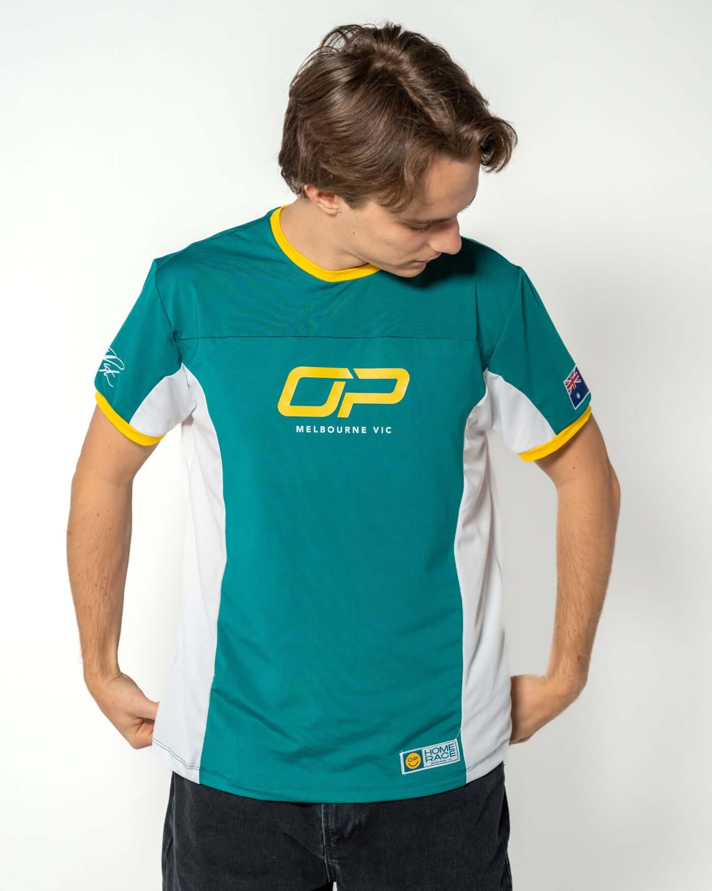 Oscar Piastri wearing the Home Race '26 Jersey in Aussie green and gold, featuring ribbed collar and performance design.