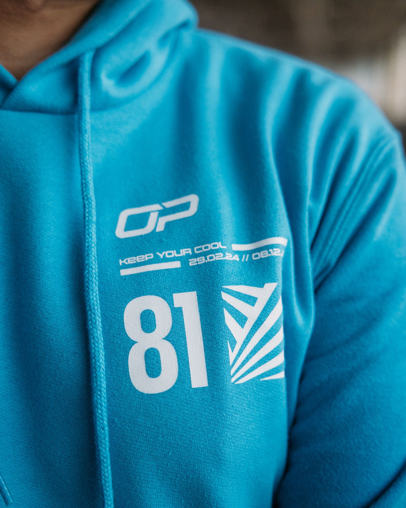 Aqua Keep Your Cool hoodie with OP logo, F1 2024 season dates, racing number 81, and dazzle effect design.