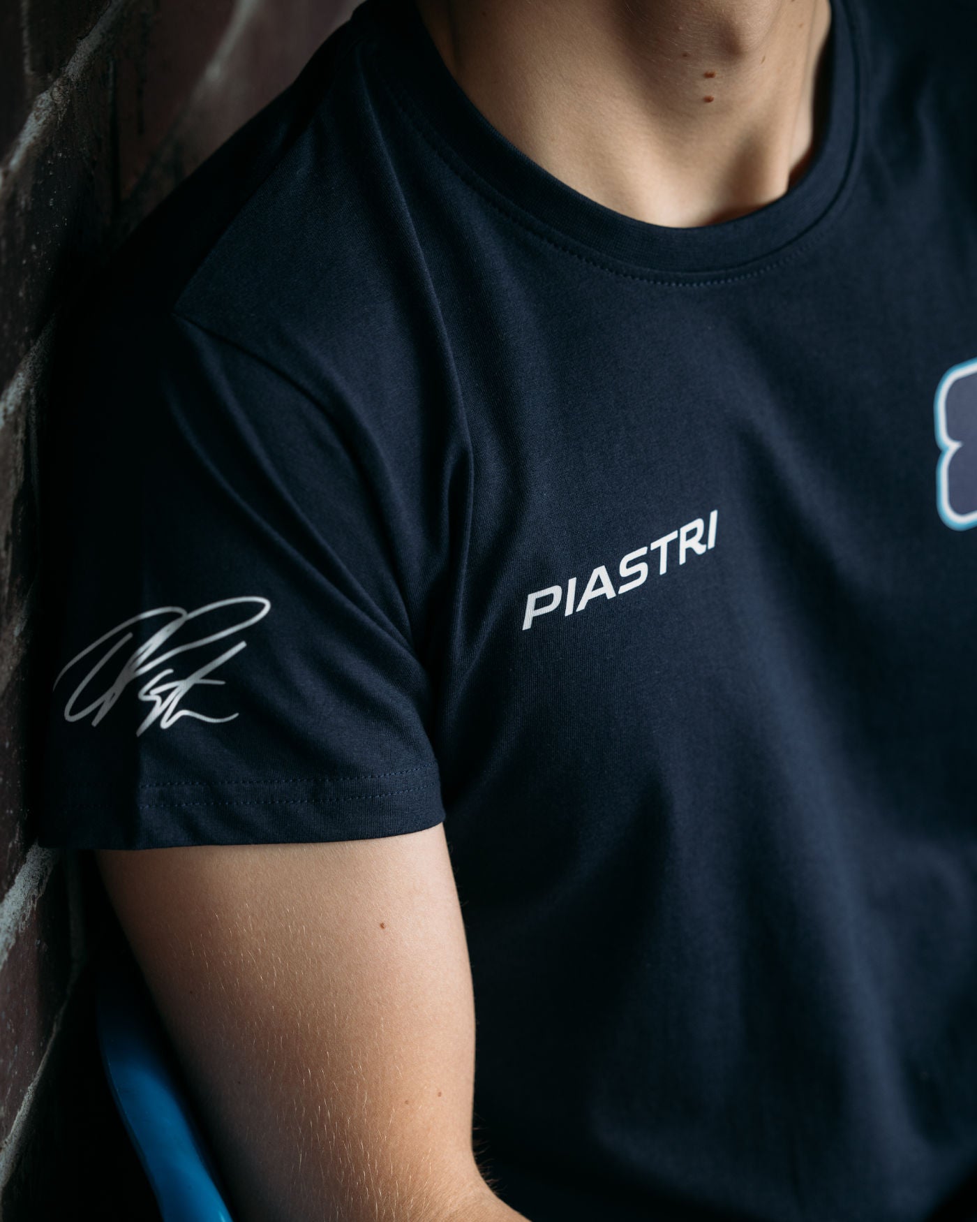 Person wearing Piastri 81 t-shirt featuring Oscar Piastri's race number, last name, and signature on sleeve