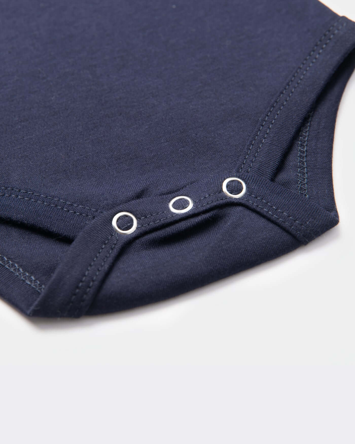 Close-up of the navy Signature Baby Body showcasing soft cotton fabric and snap closures for easy dressing.