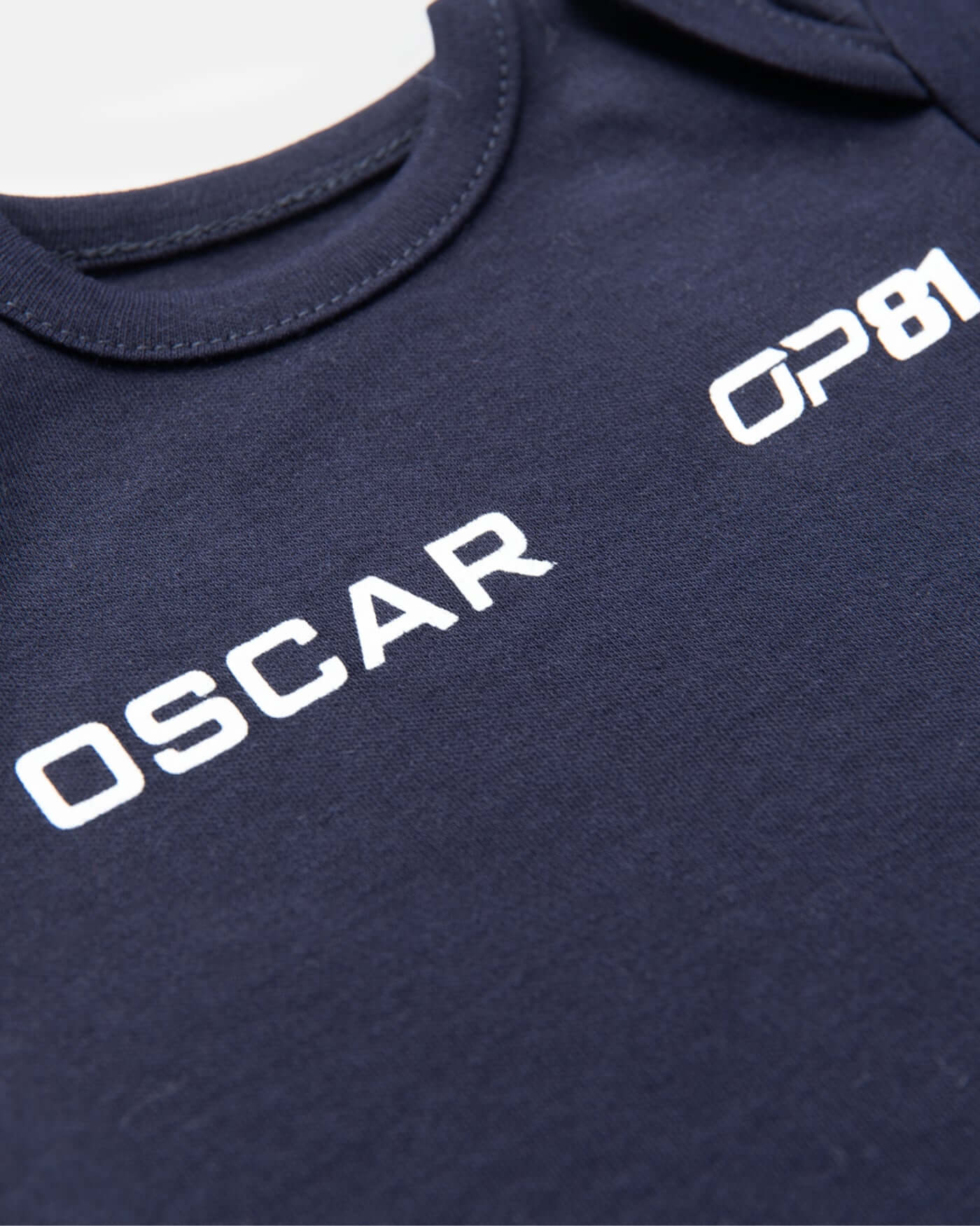 Close-up of the navy Signature Baby Body featuring Oscar and OP81 branding.