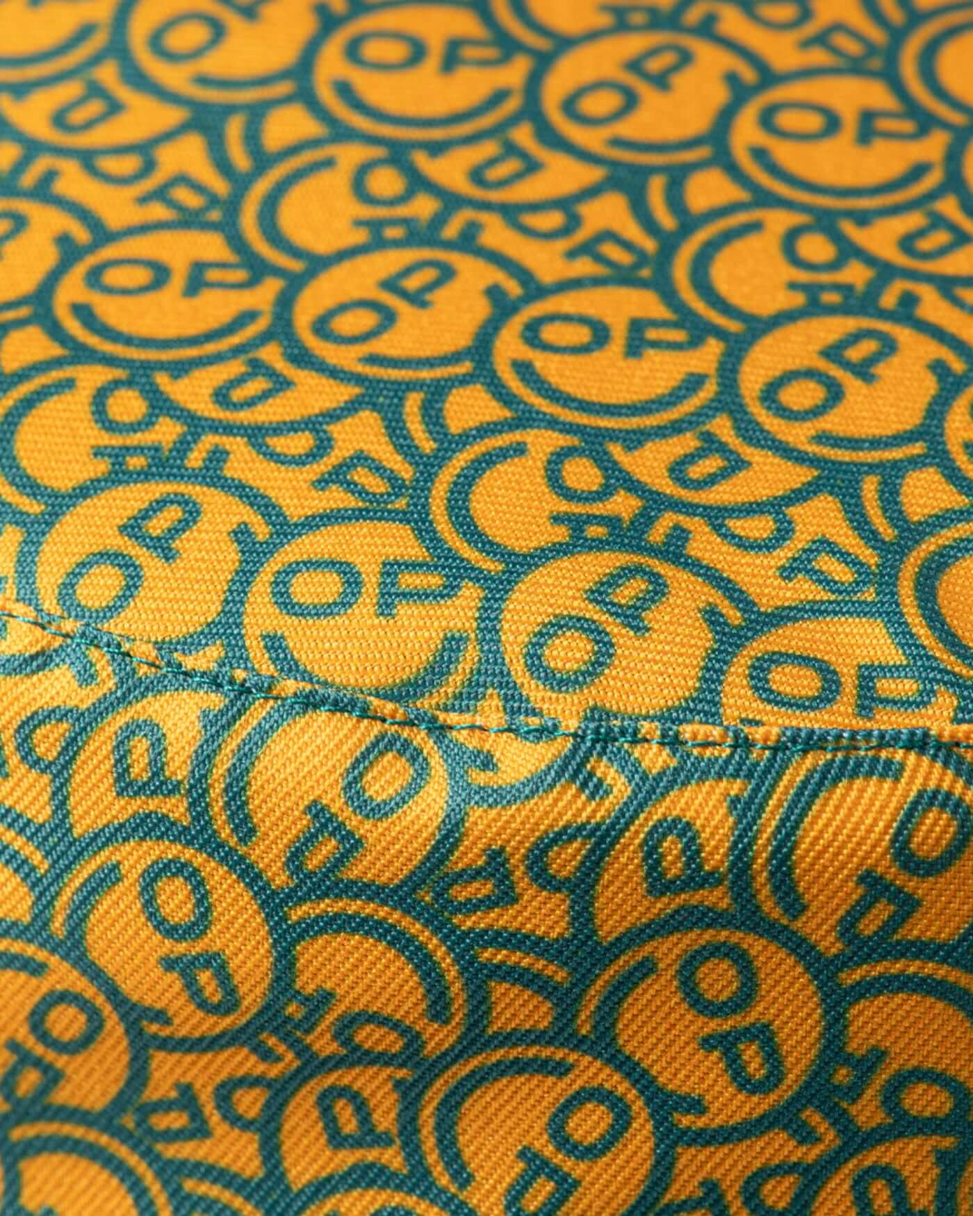 Close-up of the fabric pattern featuring the OP smiley design from the Home Race '26 Bucket Hat.