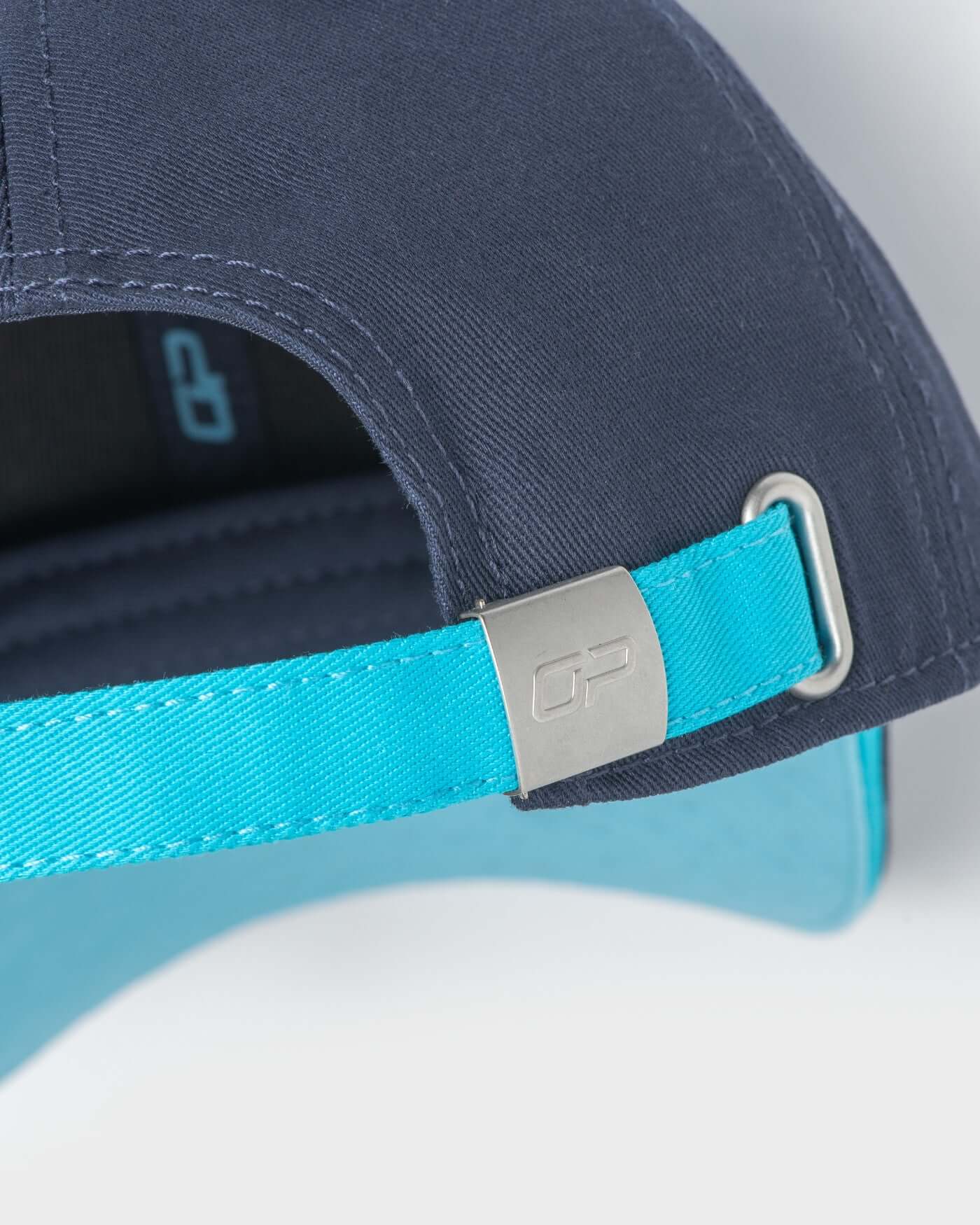 Close-up of the adjustable strap of the navy Signature Cap featuring a metal buckle and OP logo.