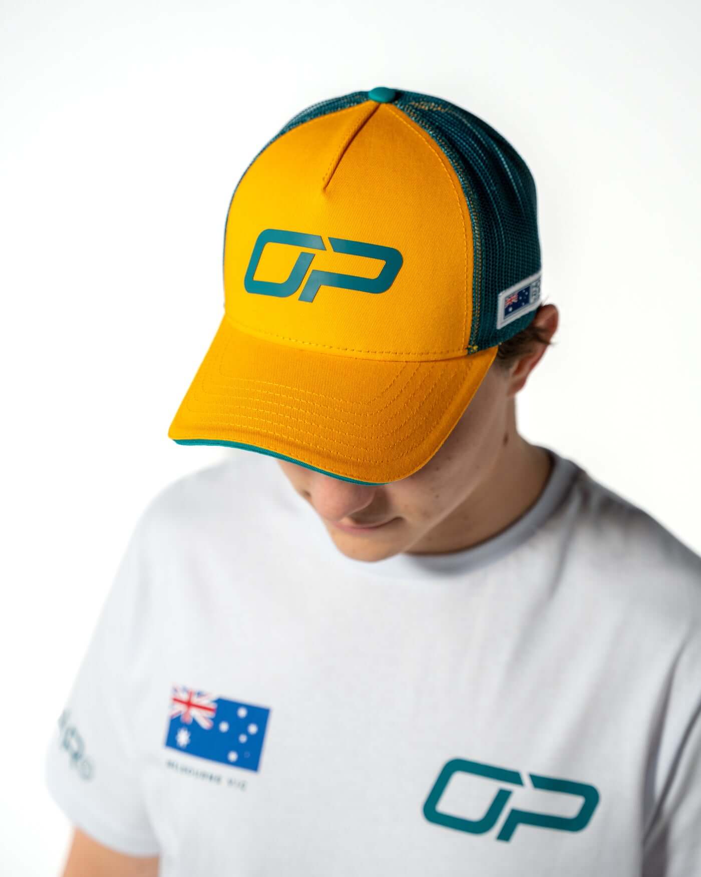 Home Race '26 Cap worn by Oscar, showcasing its bold green and gold colors and Oscar Piastri's OP design.