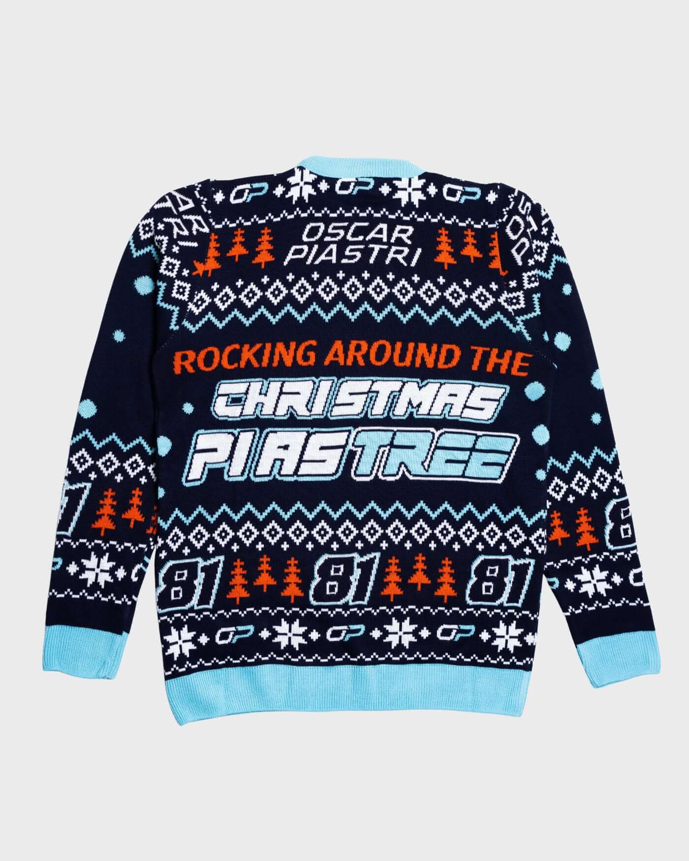 Oscar Piastri Christmas sweater with festive design, featuring holiday trees and playful "Rocking Around the Piastree" slogan.