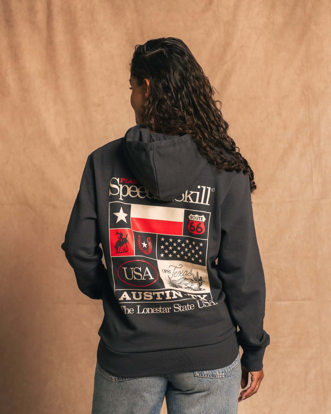 Woman wearing Texas 2024 Hoodie in Asphalt with bold Texas-inspired graphics celebrating speed and skill.