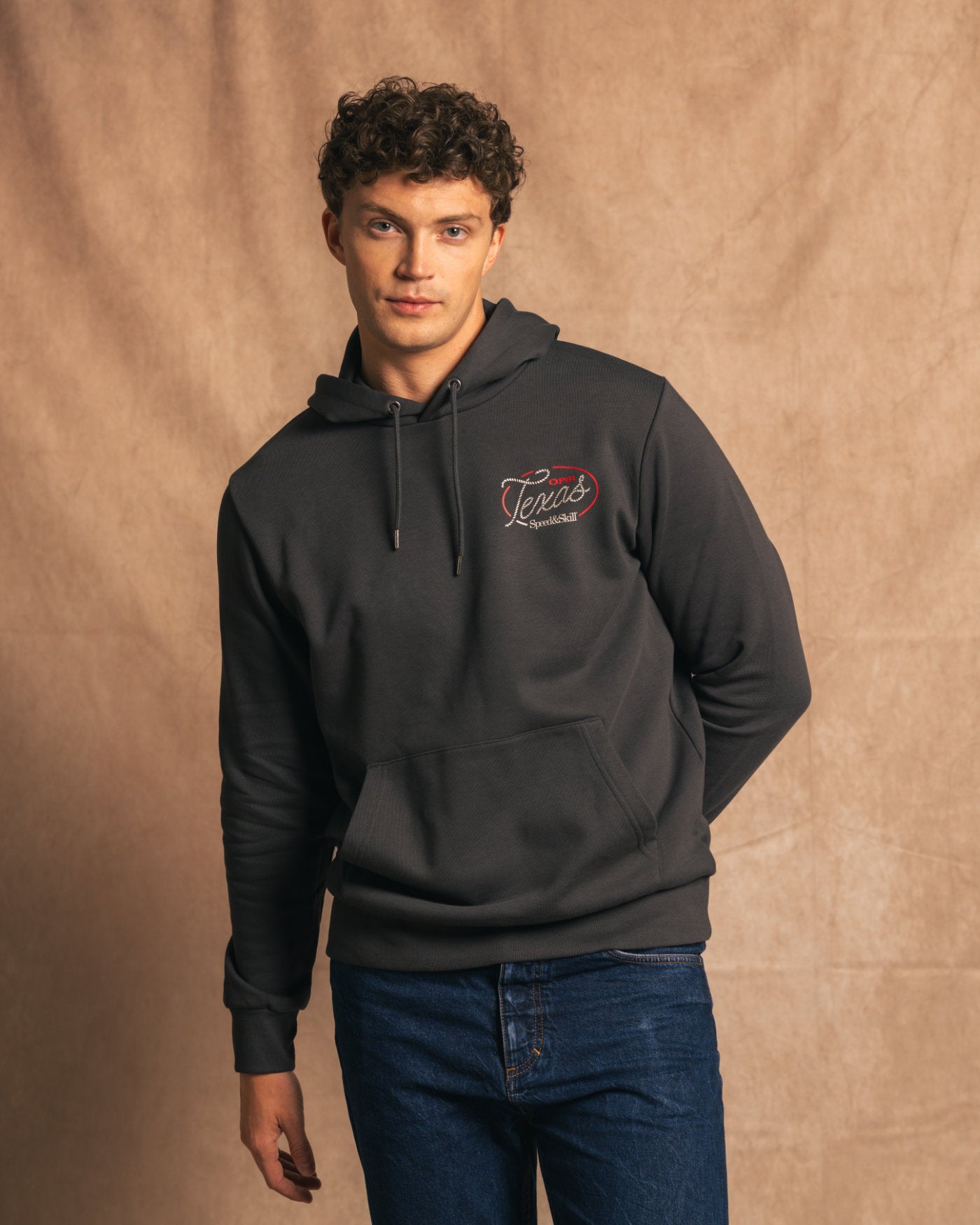 Man wearing Texas 2024 Hoodie in Asphalt, inspired by COTA and Oscar Piastri, featuring bold Texas graphics.