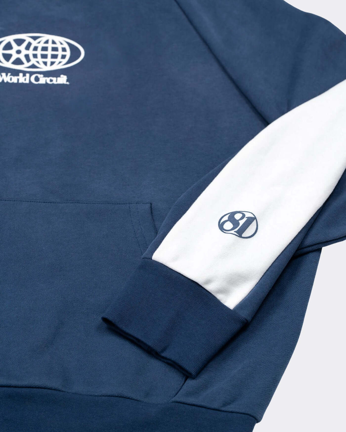 World Circuit Hoodie - Blue featuring the globe emblem and off-white racing panels on the sleeve.