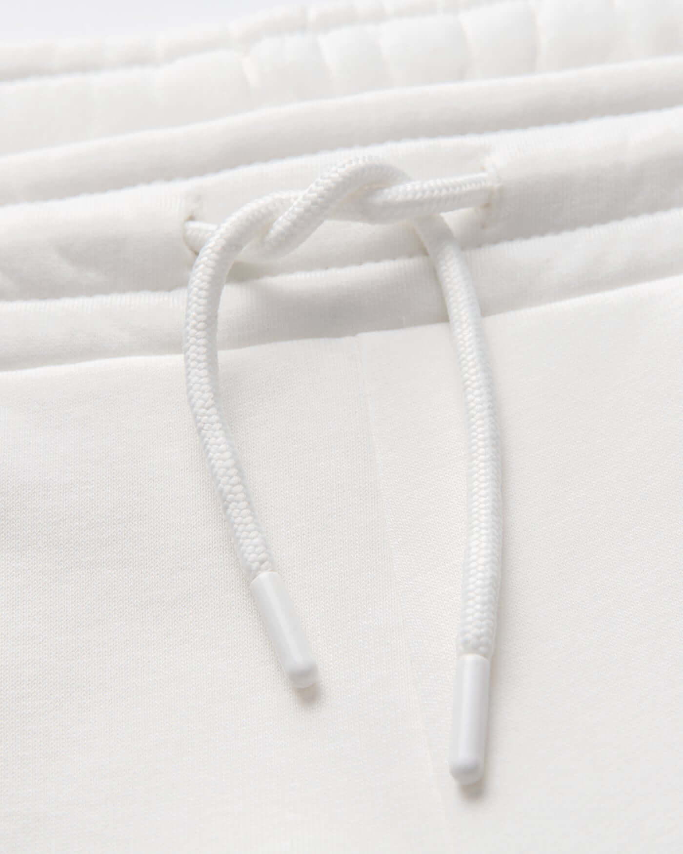 Close-up of drawstring detail on Signature Joggers - Off White, showcasing quality fabric and design.