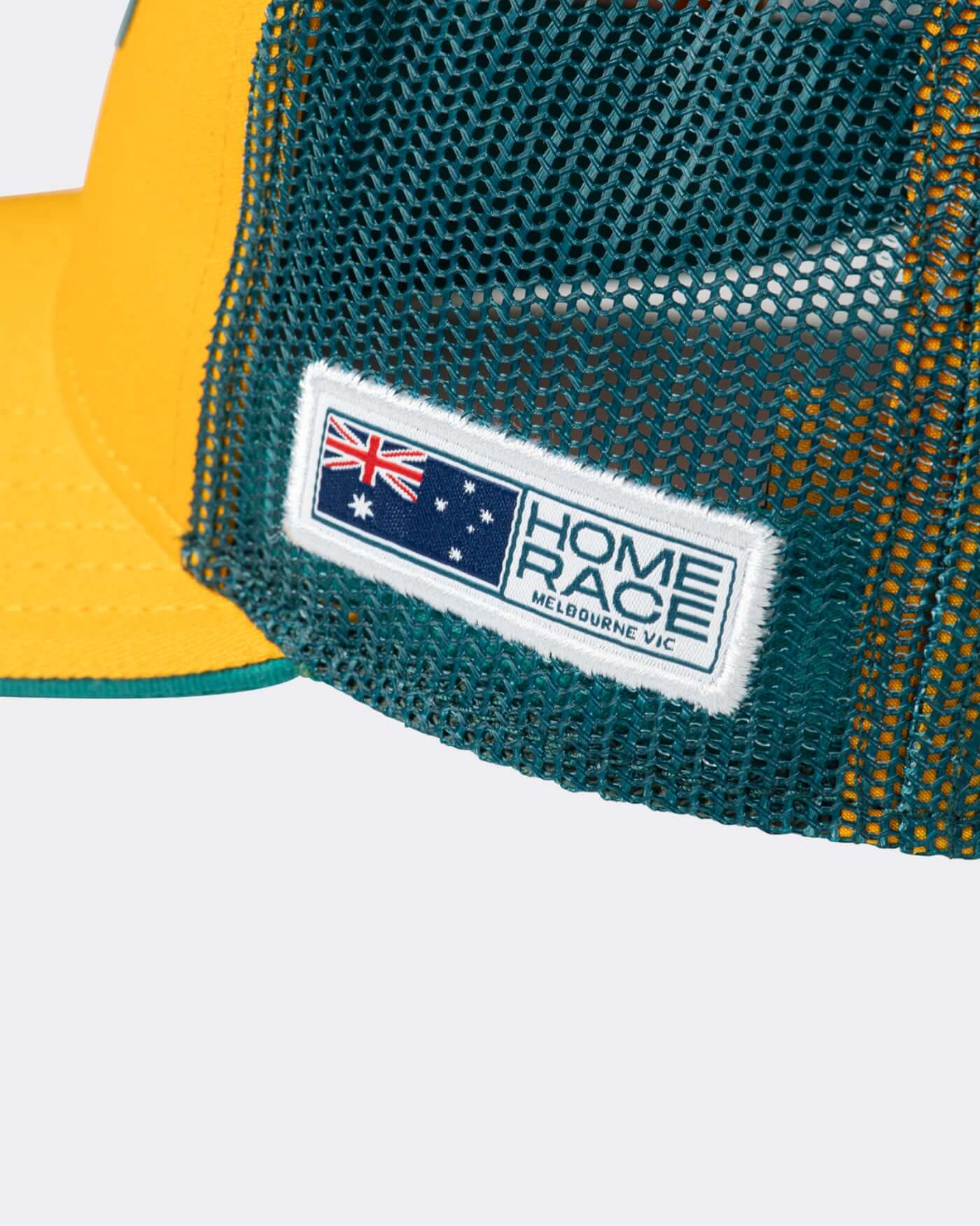 Close-up of the Home Race '26 Cap showcasing the flag patch design and mesh panels.
