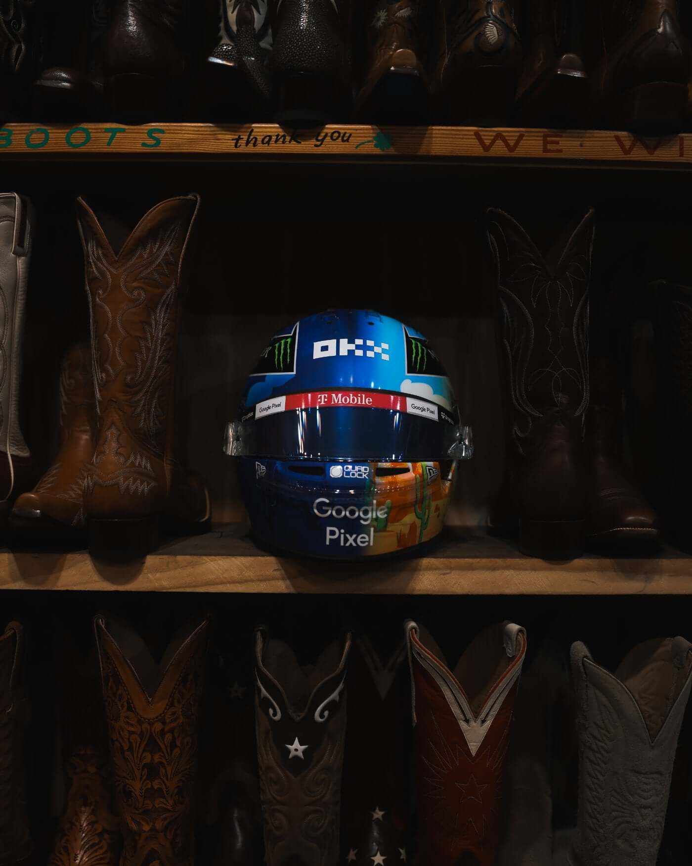 1:2 scale 2024 US Grand Prix helmet by Bell, featuring Oscar Piastri design, displayed among cowboy boots.