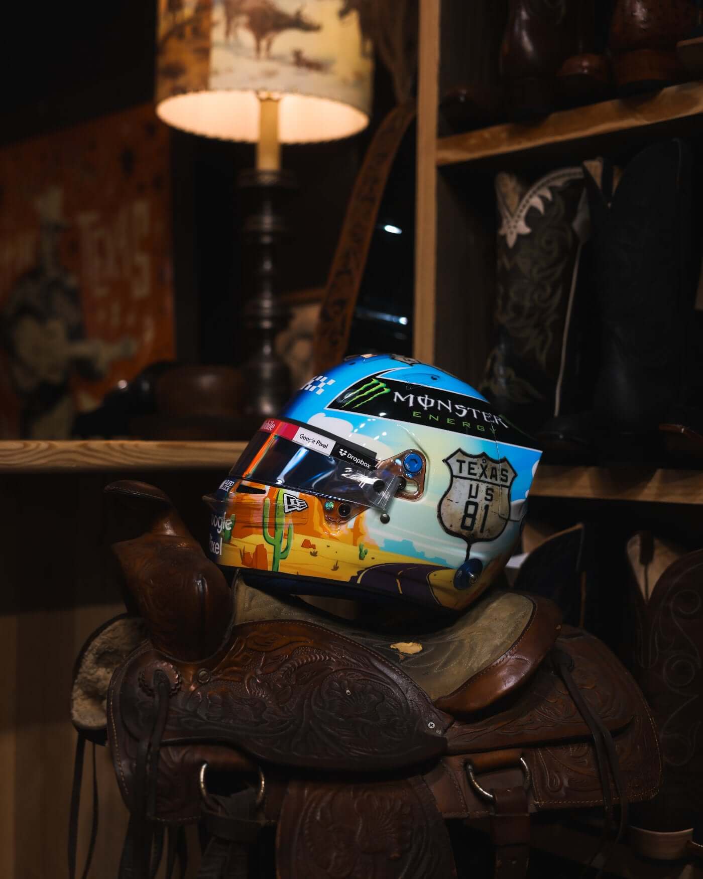 1:2 scale replica of Oscar Piastri's 2024 F1 US Grand Prix helmet on a saddle, showcasing intricate design and sponsor logos.