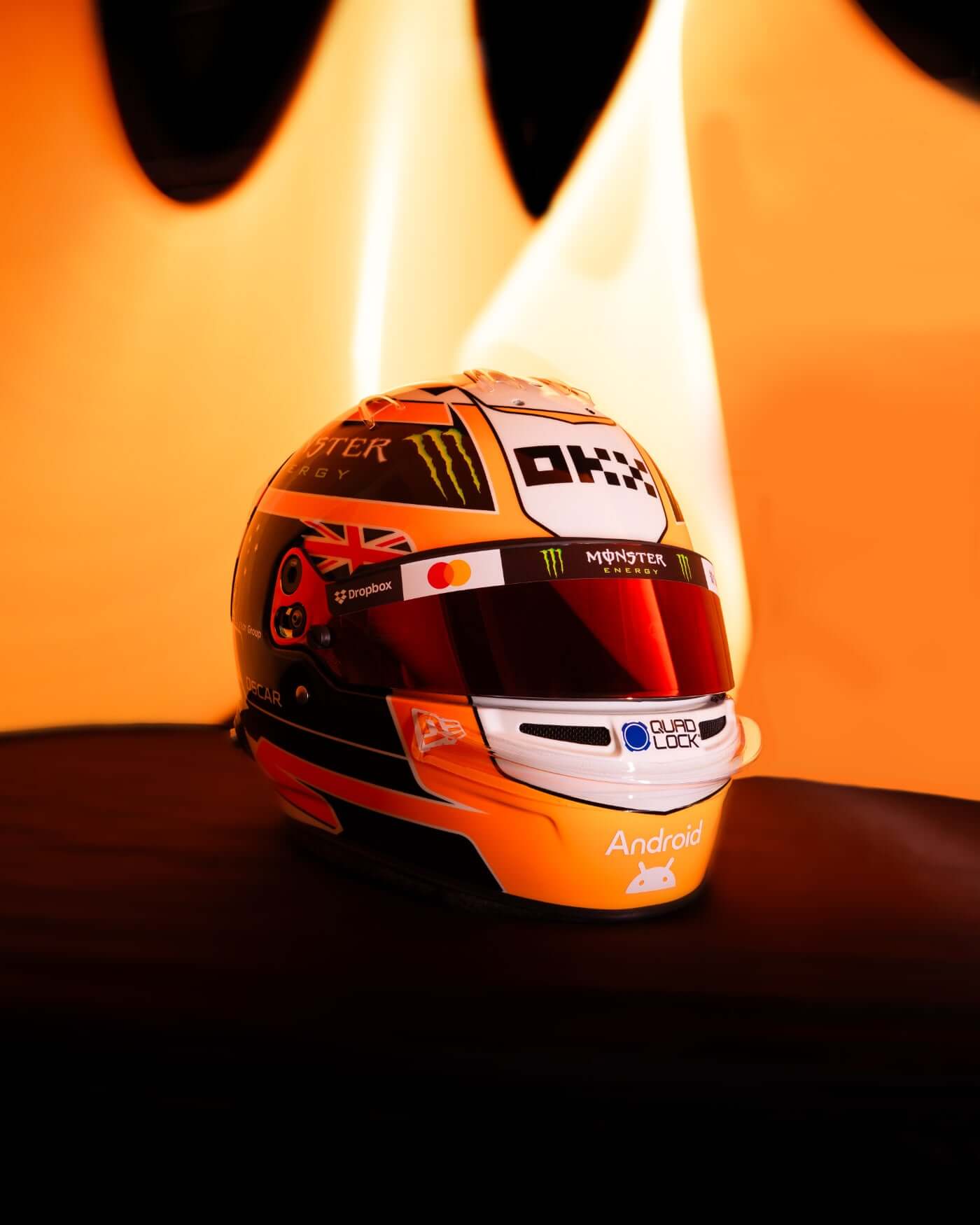 1:2 scale replica helmet of Oscar Piastri for 2025 Monaco GP, featuring iconic papaya colors and personal logo.