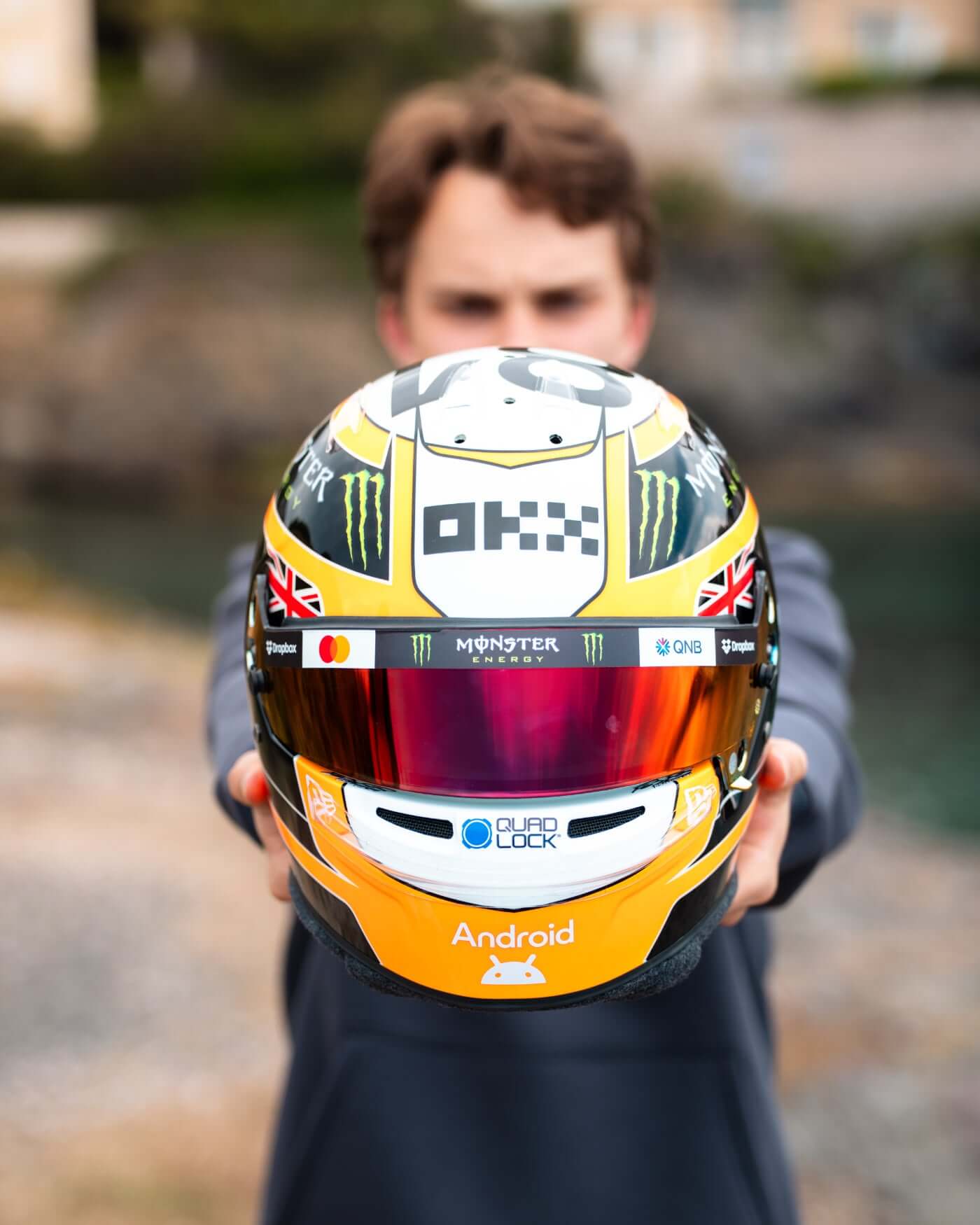 Oscar Piastri's 1:2 scale 2025 Monaco racing helmet showcasing papaya colors and logos.