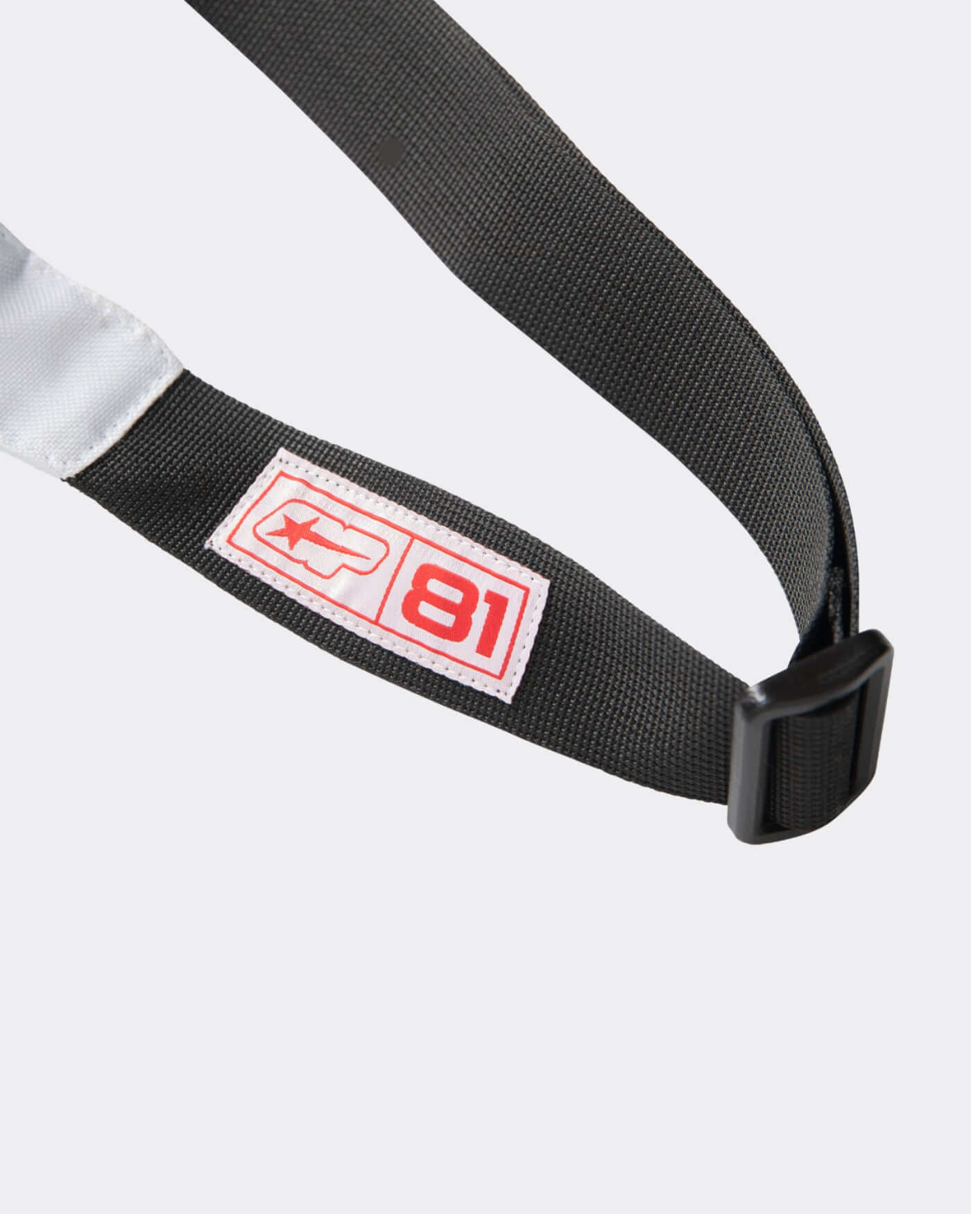 Close-up of the strap of the Origins Crossbody Bag with logo details, emphasizing its stylish design.