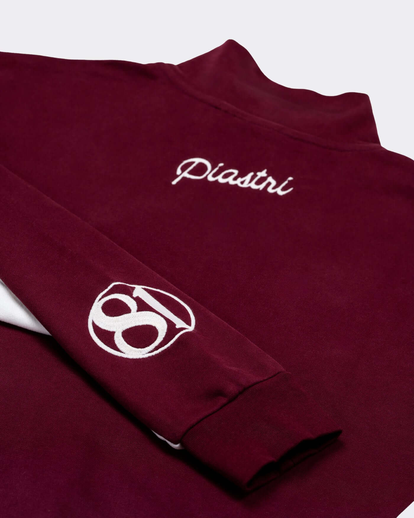 World Circuit Quarter Zip - Burgundy with embroidered Piastri signature and globe emblem detail.