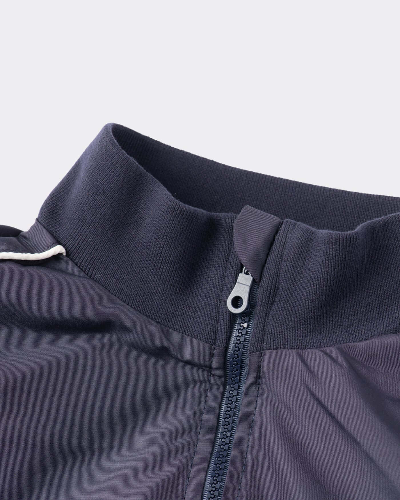 Close-up of the collar and zipper of Oscar's navy Signature Racing Jacket, showcasing quality and design details.