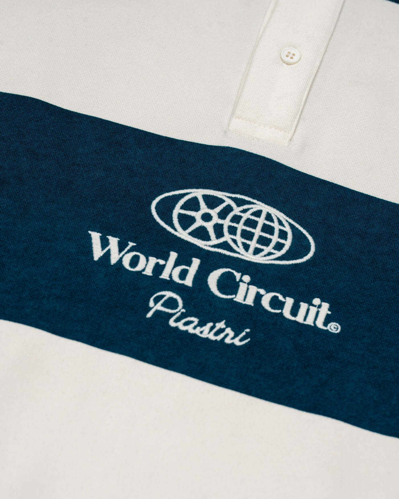 Close-up of the World Circuit Rugby Shirt featuring block stripes and embroidered logo on the chest.