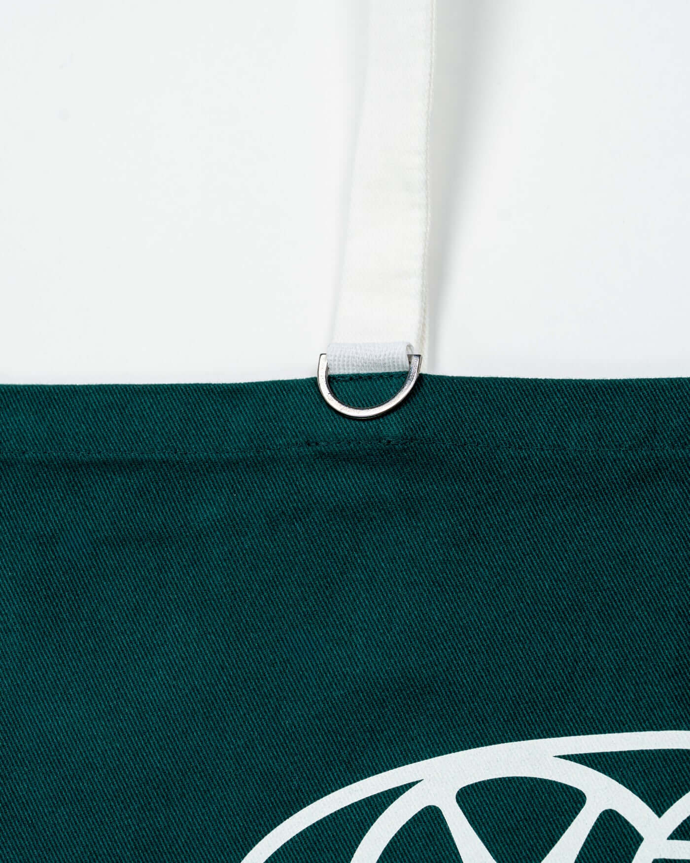 Close-up of the D-ring detail on the World Circuit Tote Bag, highlighting its sturdy cotton canvas design.