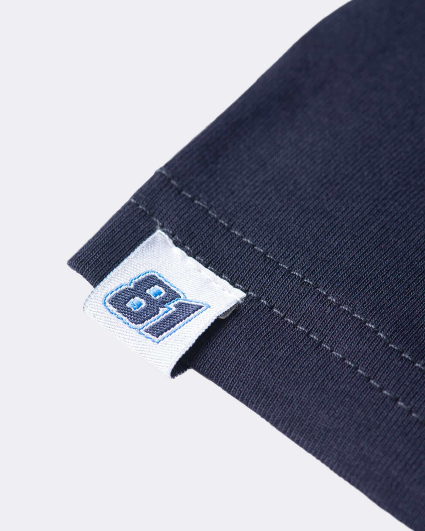 Close-up of the navy OP81 Signature T-Shirt sleeve tag featuring the race number 81 for stylish casual wear.