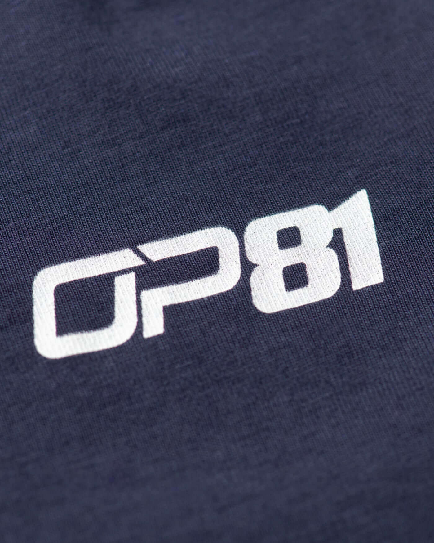 Close-up of the OP81 logo on a navy t-shirt, showcasing the iconic design and premium quality fabric.