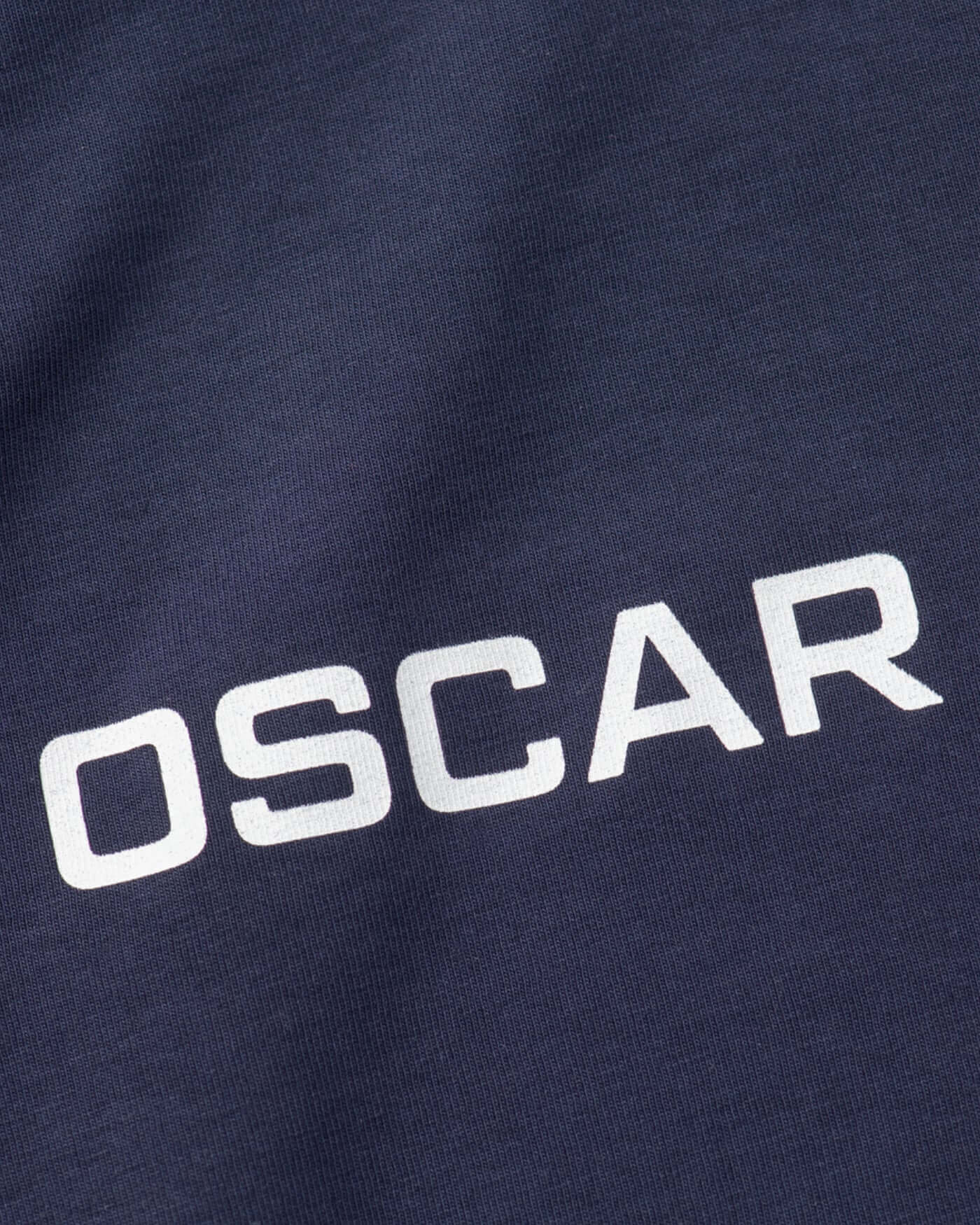 Close-up of the OP81 Signature T-Shirt in navy featuring the name 'OSCAR' in bold white letters.