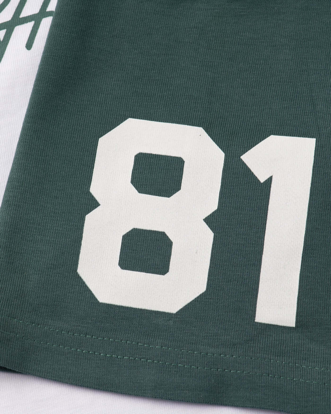Close-up of a green t-shirt featuring a white '81' print, highlighting its sporty design and vibrant color.