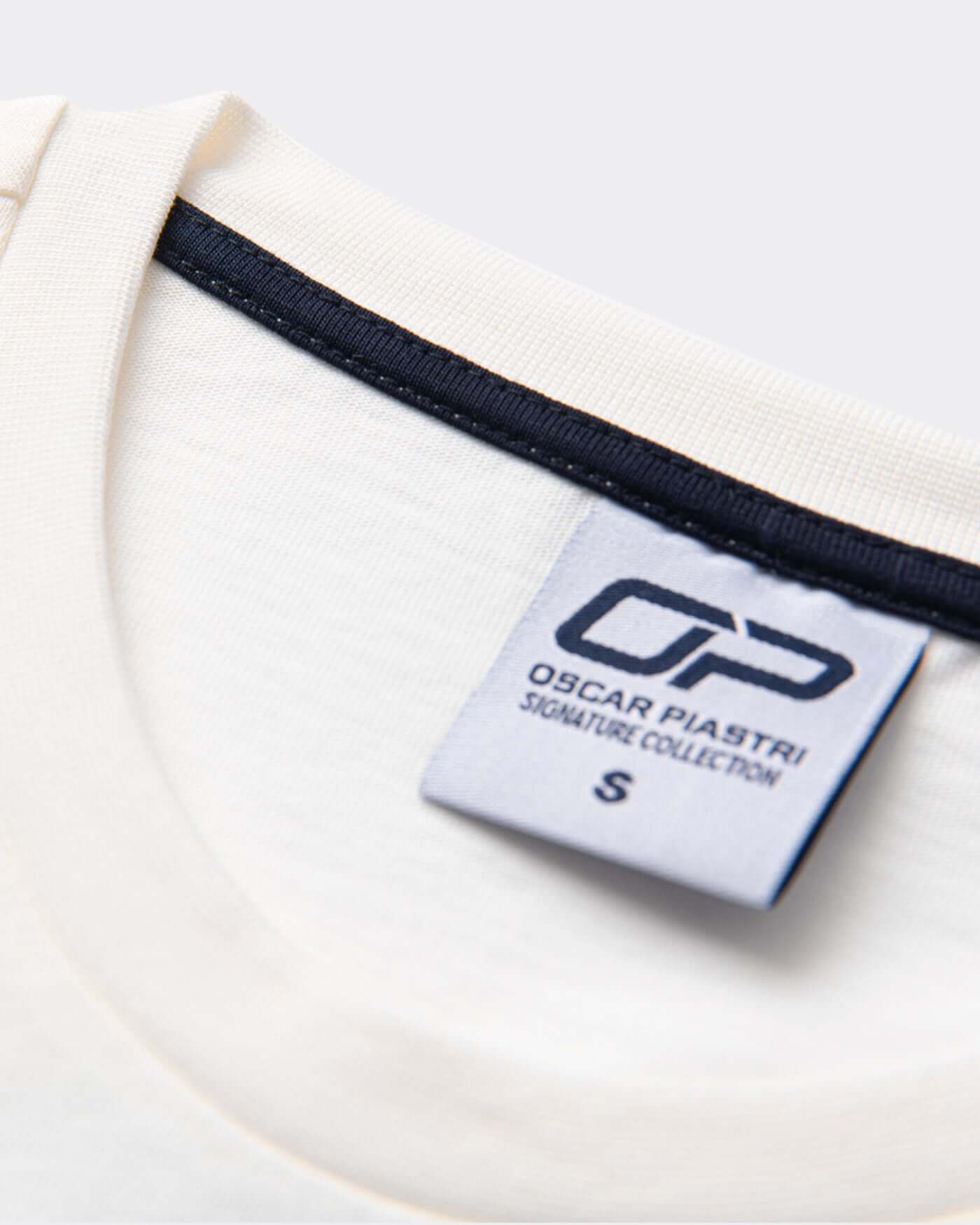 Close-up of the label on the Signature Oversized T-Shirt - Off White showing the brand details.