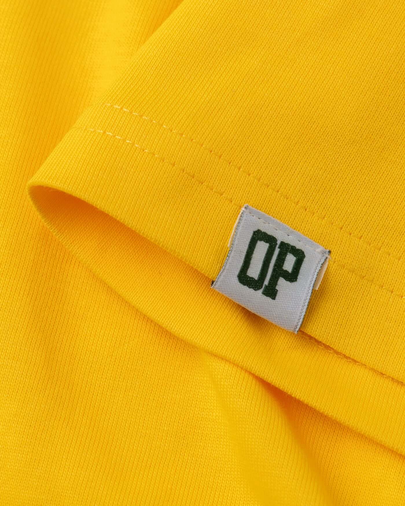 Close-up of a bright yellow t-shirt fabric featuring a stitched label with 'OP' branding.