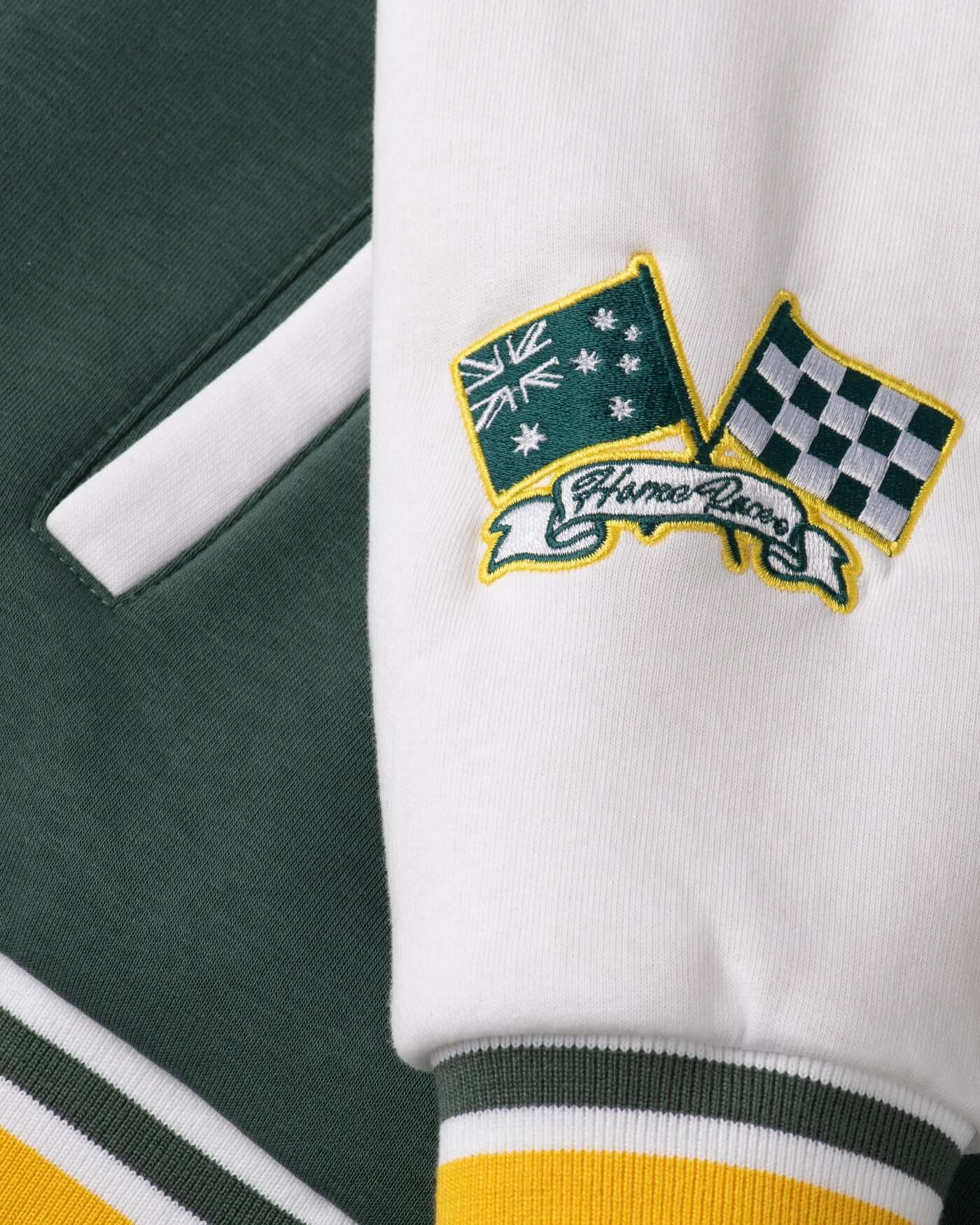 Close-up of Home Race Varsity Jacket featuring Australian flag and checkered flags embroidered patches.
