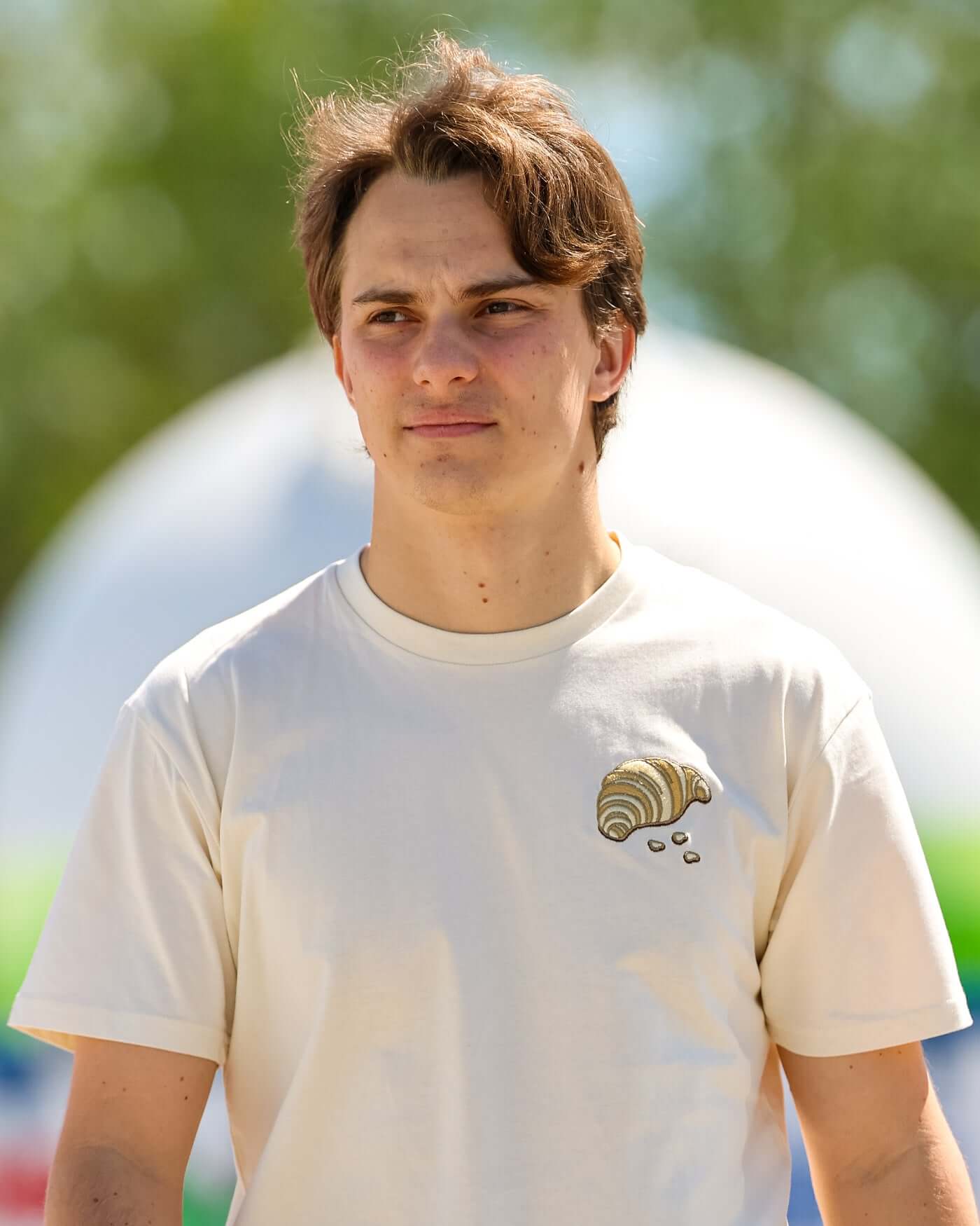 Oscar Piastri wearing The Pastry Piastee t-shirt with a ribbed collar, showcasing the unique design.