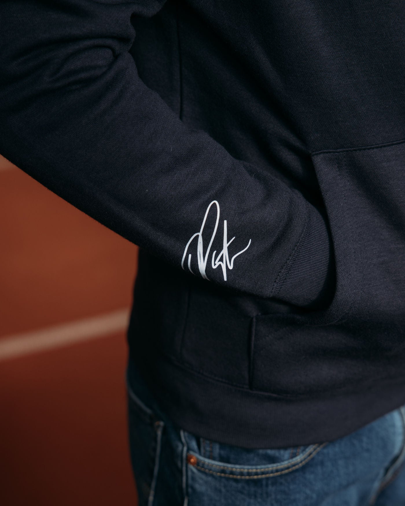 Oscar Piastri signature on sleeve of OP Signature Hoodie with iconic logo, showcasing stylish and sophisticated design.