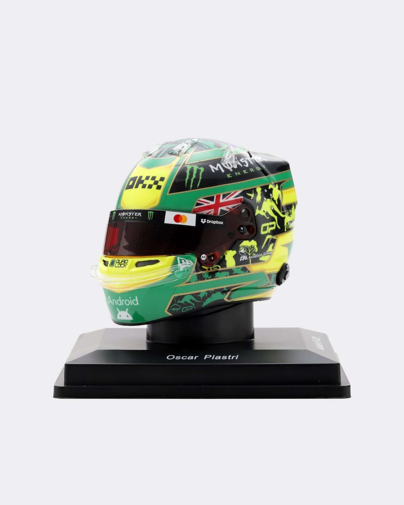 1:5 scale 2025 Australia Helmet - Oscar Piastri displayed on a stand, showcasing vibrant green and yellow design.