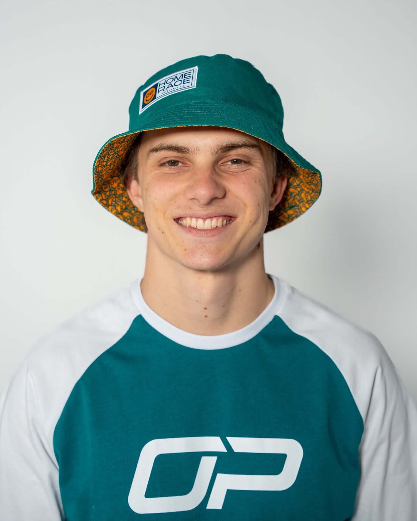 Oscar Piastri wearing the Home Race '26 Bucket Hat in Aussie green and gold, perfect for summer.