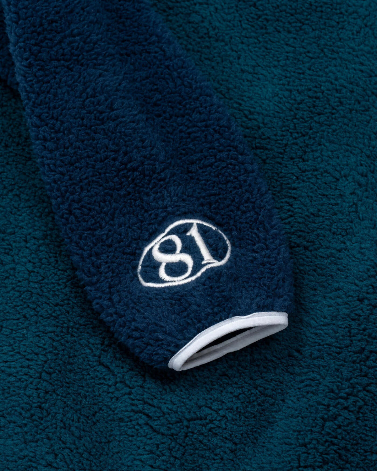 World Circuit Fleece close-up showing the soft fabric and embroidered detail on the sleeve.