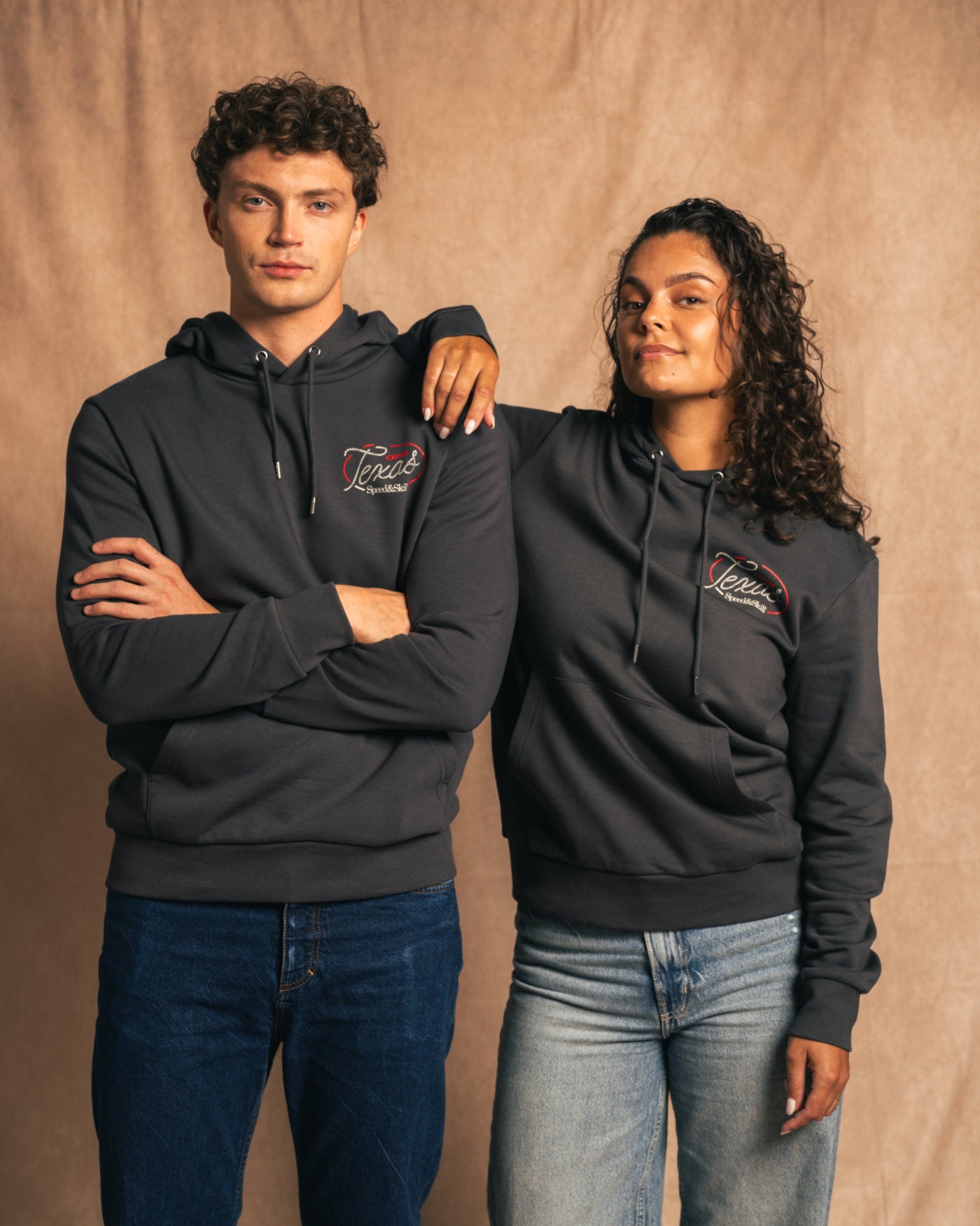 Two models wearing Texas 2024 Hoodie in Asphalt with Texas-inspired graphics, embodying the spirit of Formula 1 and Western culture.