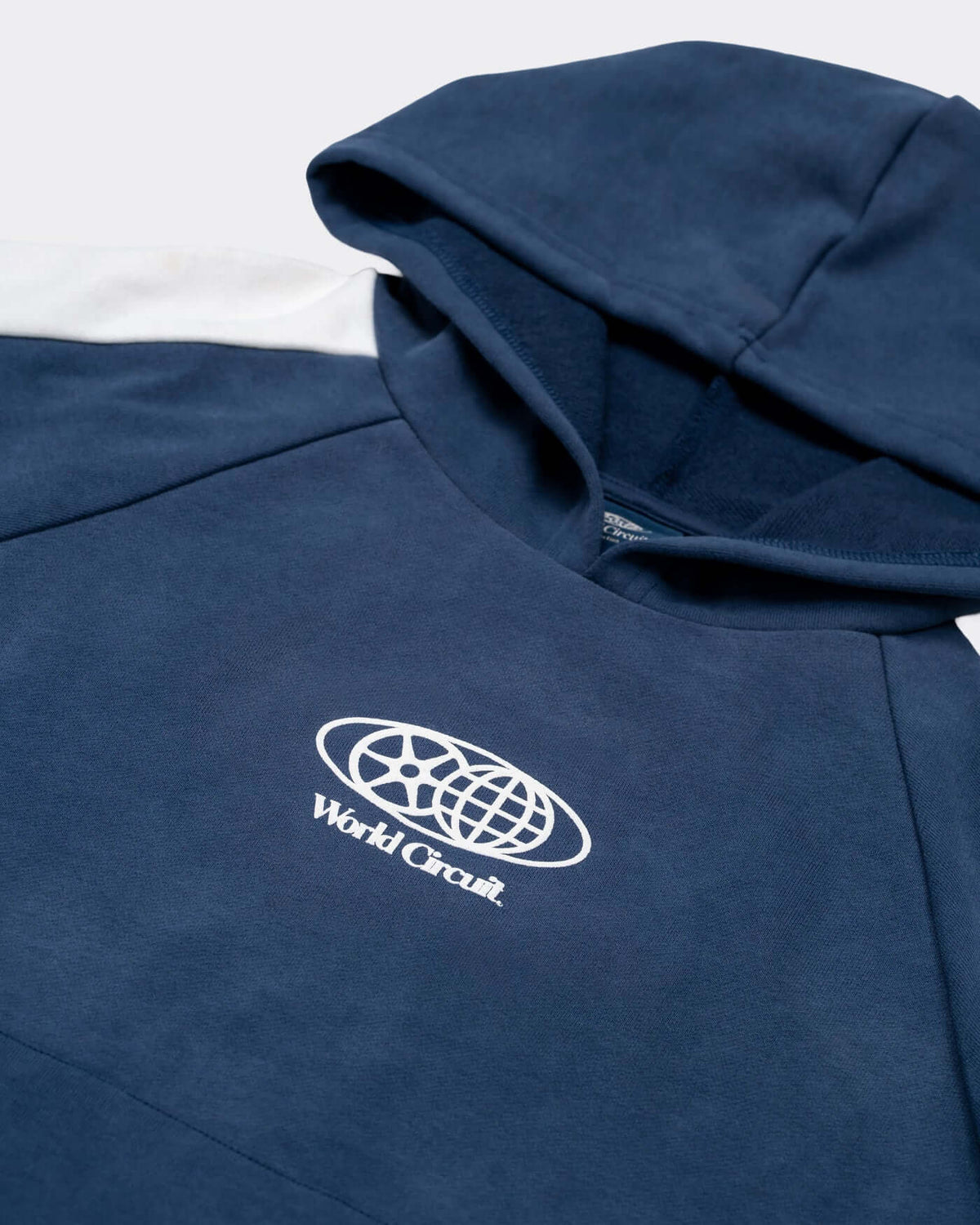 World Circuit Hoodie - Blue with off-white racing panels and globe emblem on the chest.