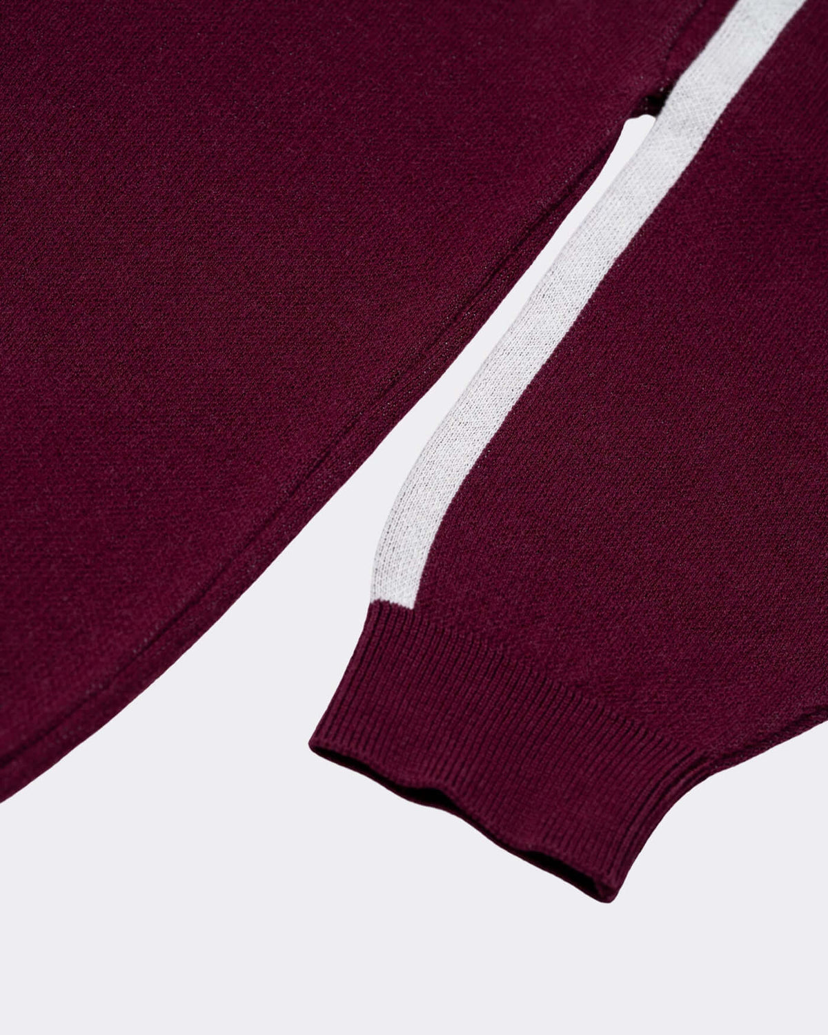 World Circuit Knitted Sweater - Burgundy close-up showing ribbed trims and off-white jacquard stripe on sleeve.
