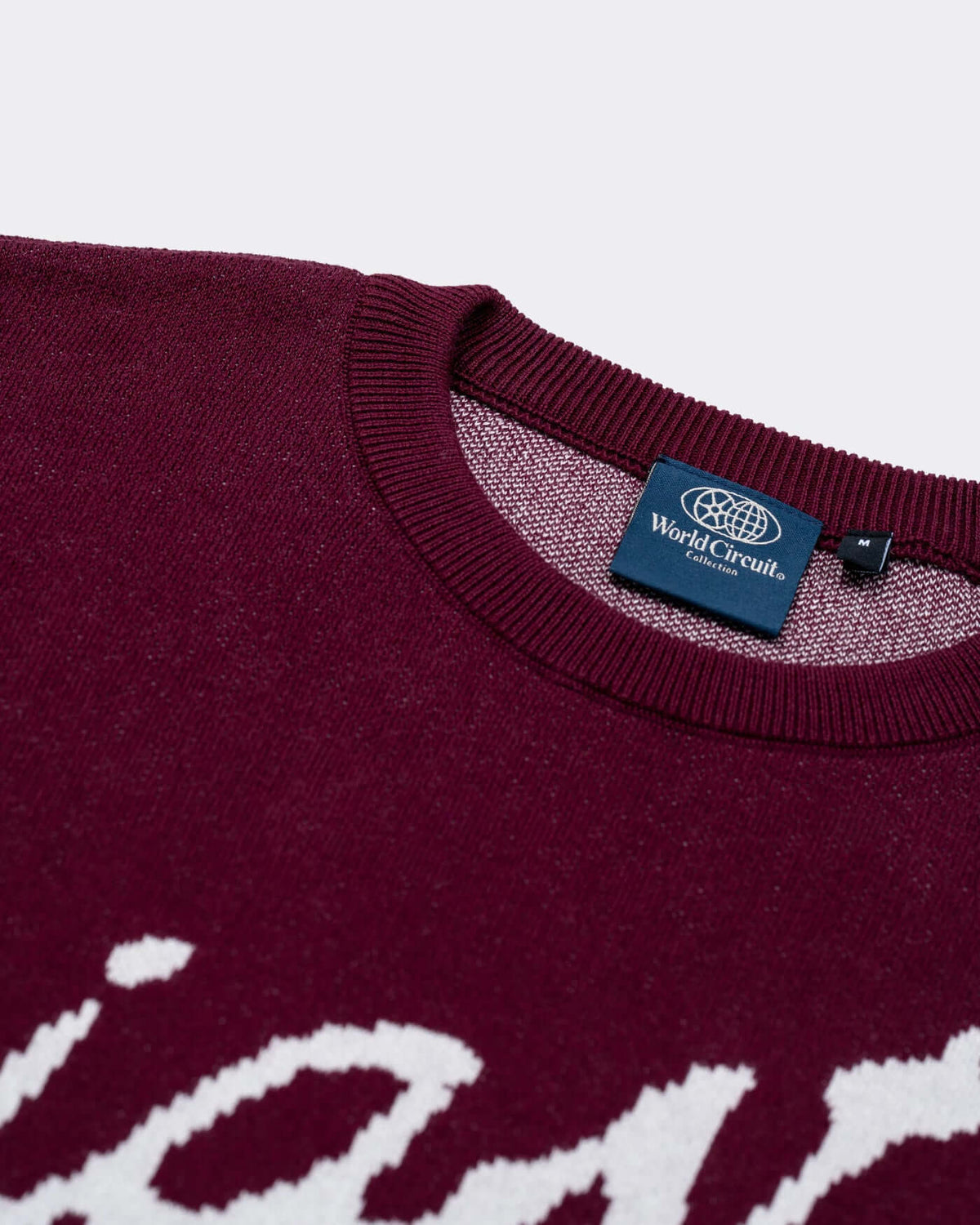 World Circuit Knitted Sweater - Burgundy with jacquard motifs and ribbed round neck detail.