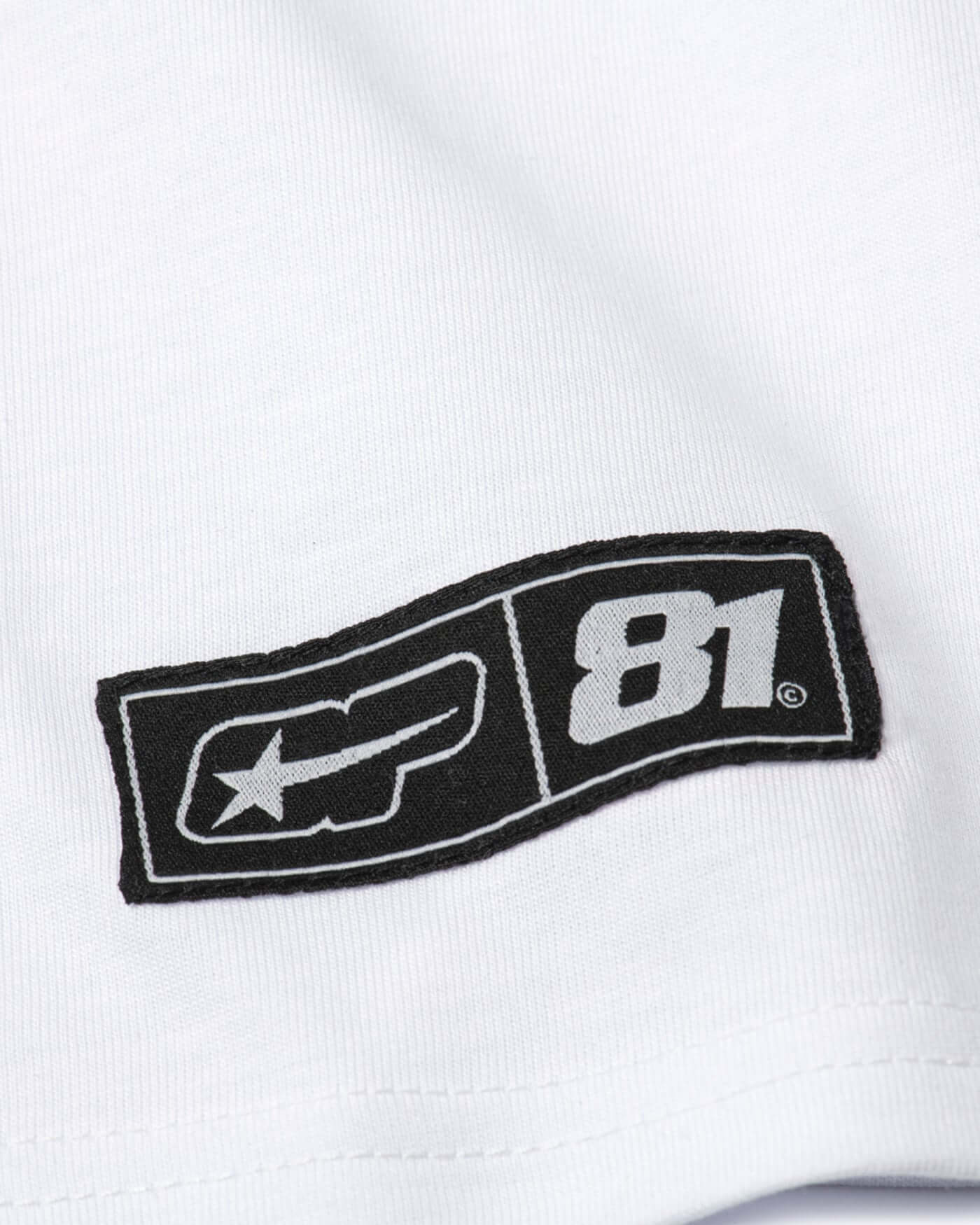Close-up of the logo on the Origins Crop Tee featuring a black and white design with number 81.