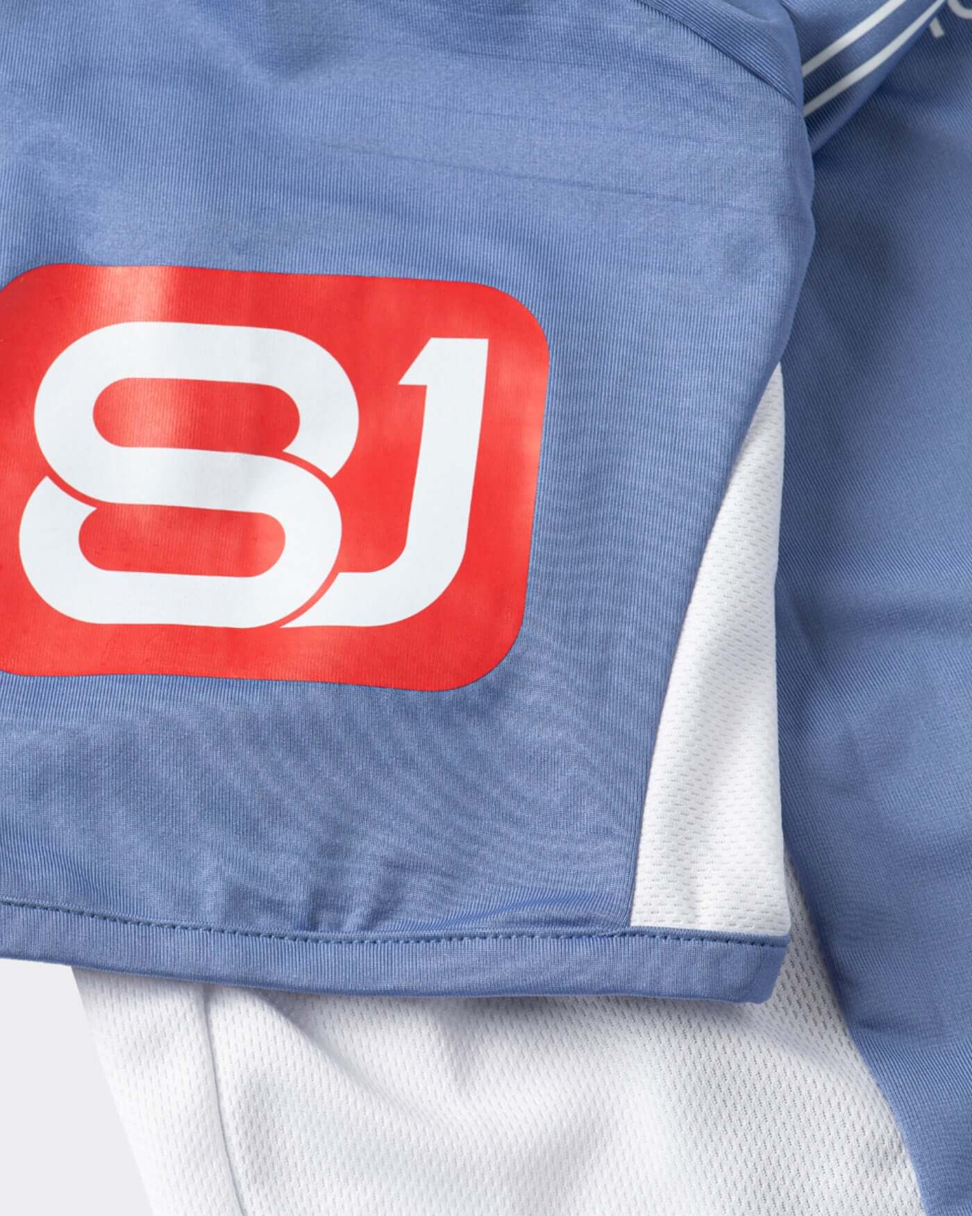 Close-up of the Origins Jersey showcasing its blue fabric and distinctive logo detail.