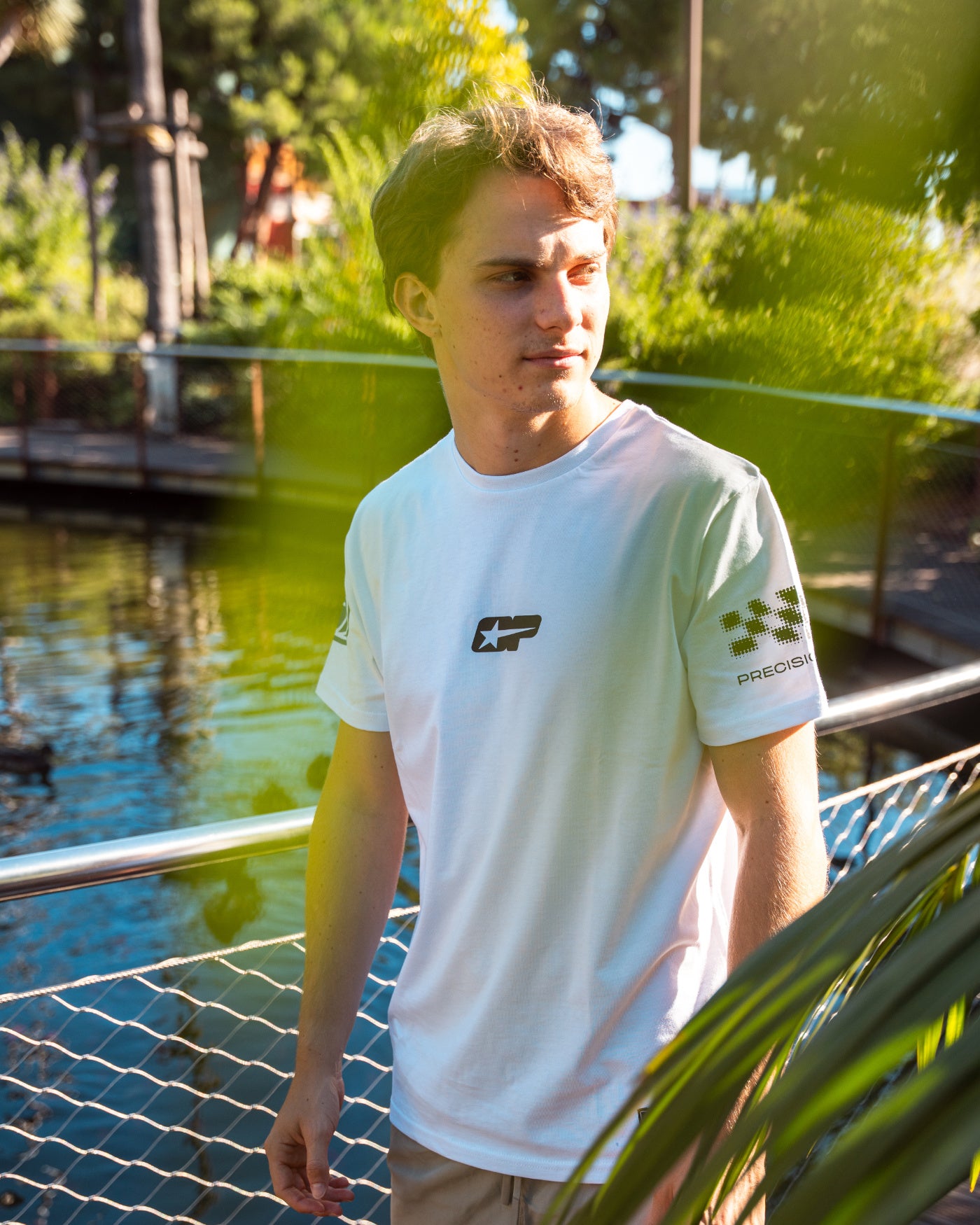Origins T-Shirt - Oscar wearing in a garden setting, showcasing retro motorsport graphics and casual style.
