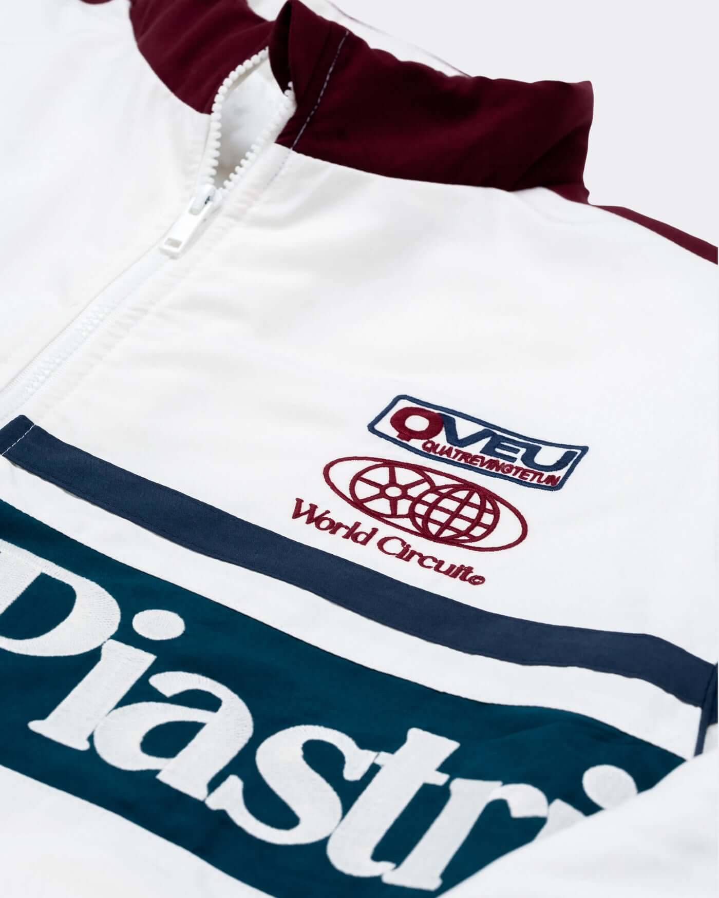 Close-up of the World Circuit Race Jacket featuring Piastri embroidery and vibrant color panels.