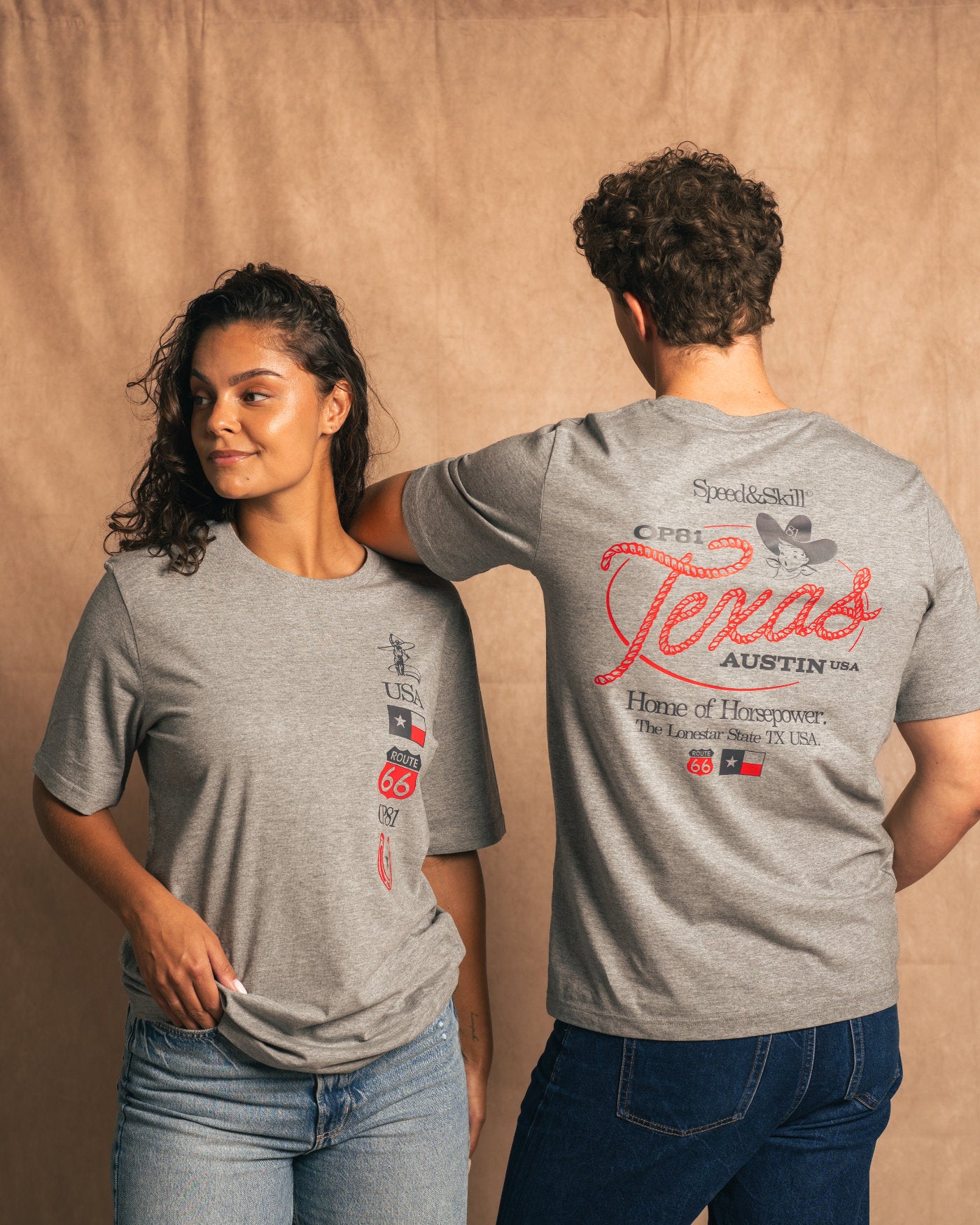 "Texas 2024 T-Shirt in Light Grey featuring Western and Formula 1-inspired graphics, celebrating speed and skill, worn by two people."